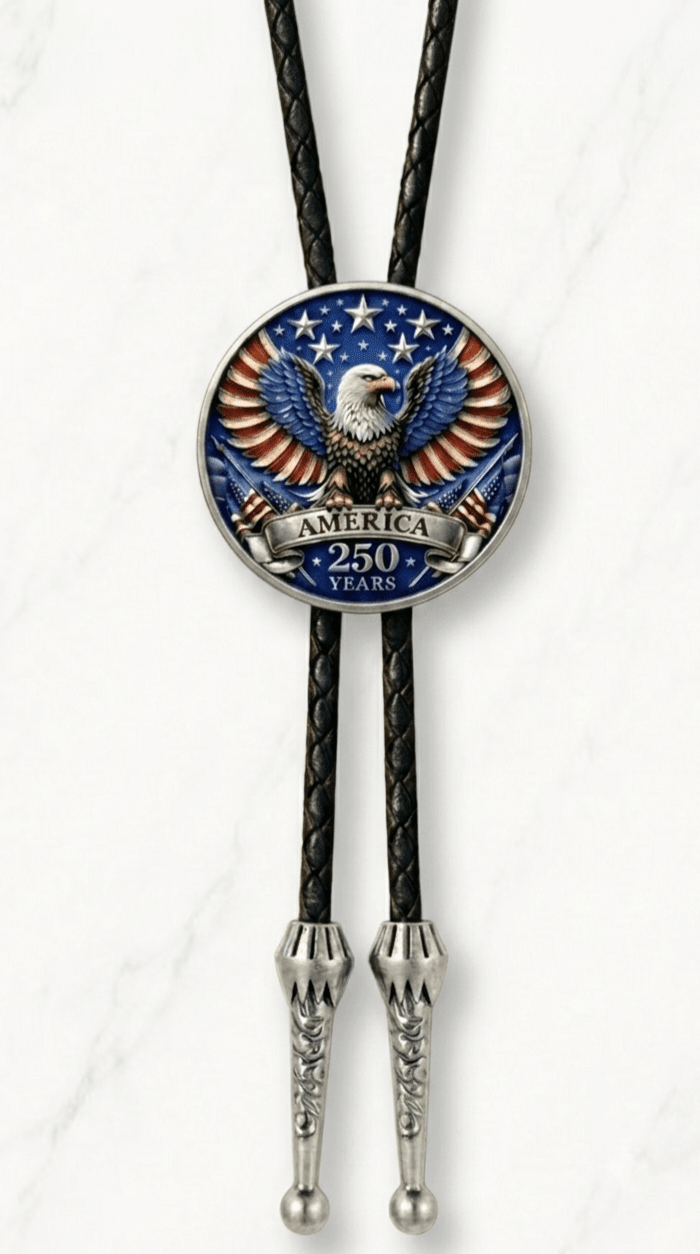 Reverse side of the Stars And Stripes Bolo Tie featuring a patriotic bald eagle with red white and blue wings, America 250 Years lettering, black braided leather, and silver-tone tips on white ma
