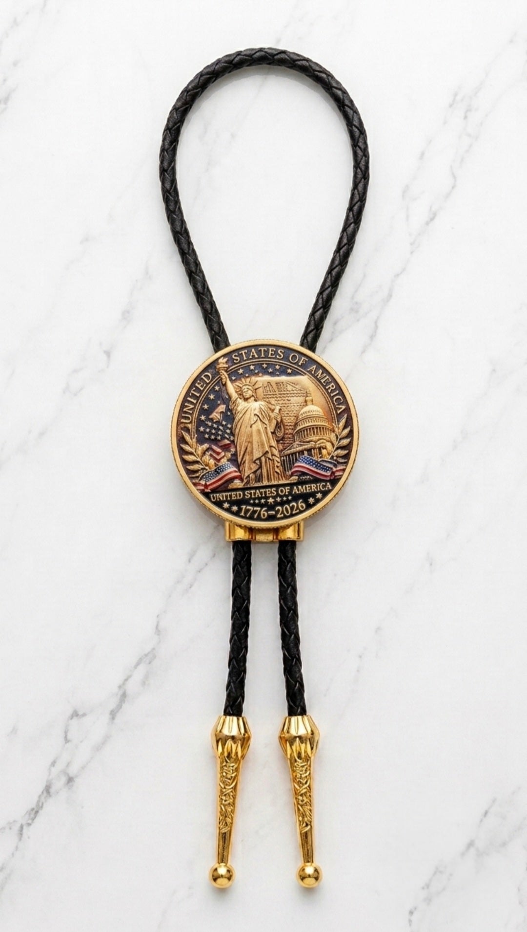 America 250 Bolo Tie Side B featuring the Statue of Liberty, United States Capitol, American flags, and the inscription "United States of America 1776–2026" mounted on premium black braided leather with polished gold engraved Western bolo tips.
