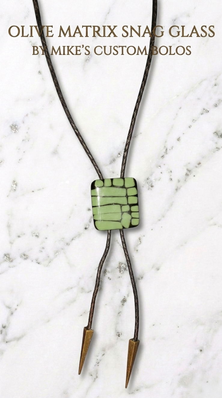 Olive Matrix Snag Glass Bolo Tie on marble background by Mike’s Custom 