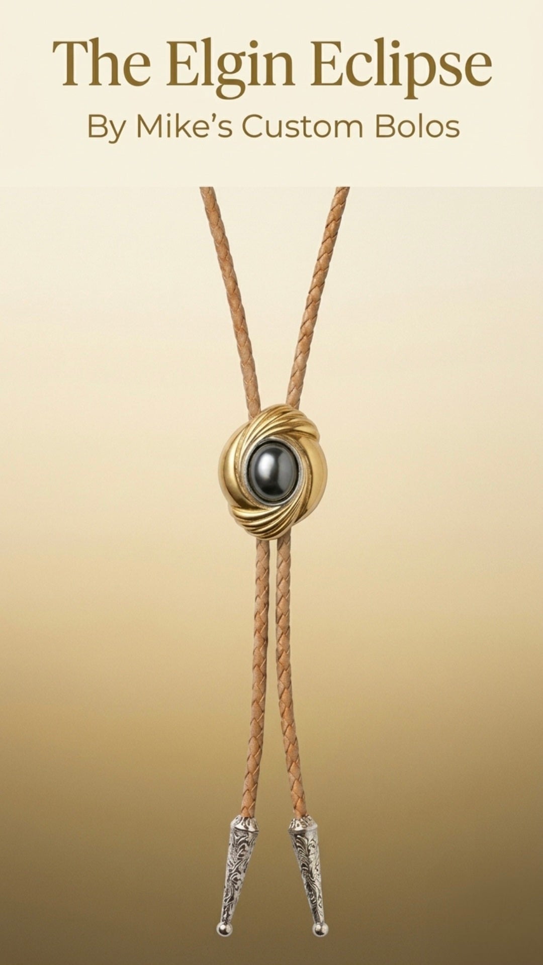 The Elgin Eclipse handcrafted custom bolo tie featuring a black cabochon centerpiece, gold-toned swirl design, braided leather cords, and engraved silver bolo tips.