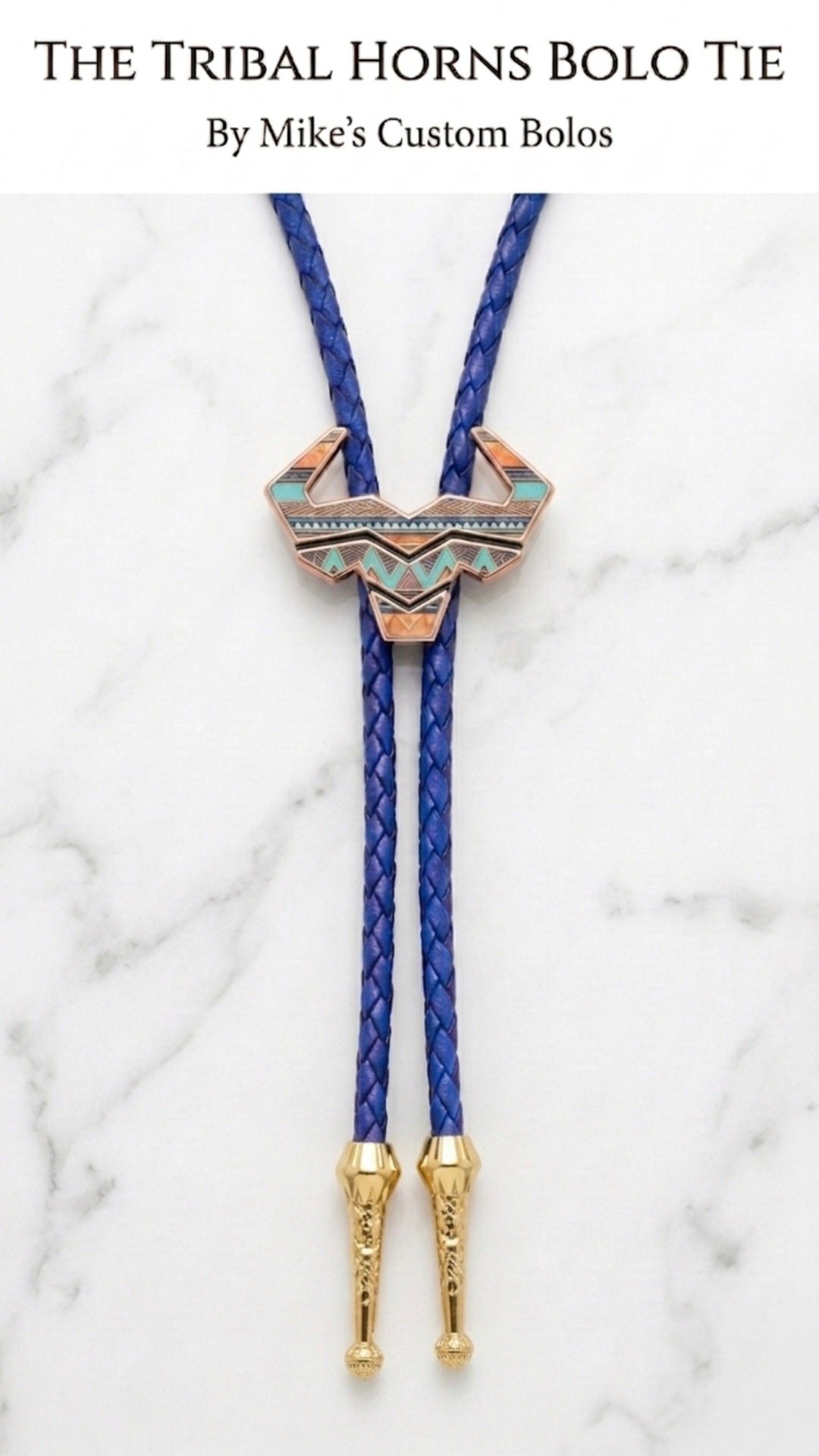 Tribal horns bolo tie with blue leather cord and gold hardware on a white marble background