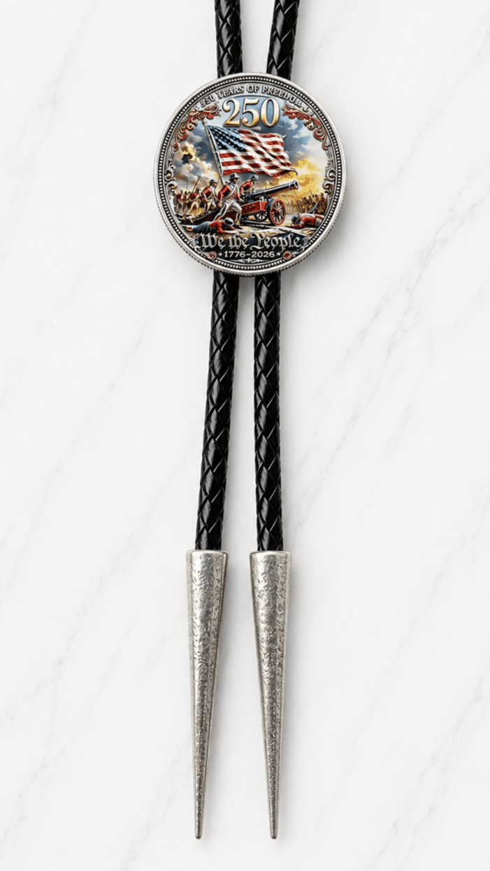 Reverse side of the Red White and Blue 250th Anniversary two-sided collector’s bolo tie featuring an American flag, Revolutionary War scene, cannon, We the People text, and 1776–2026 details